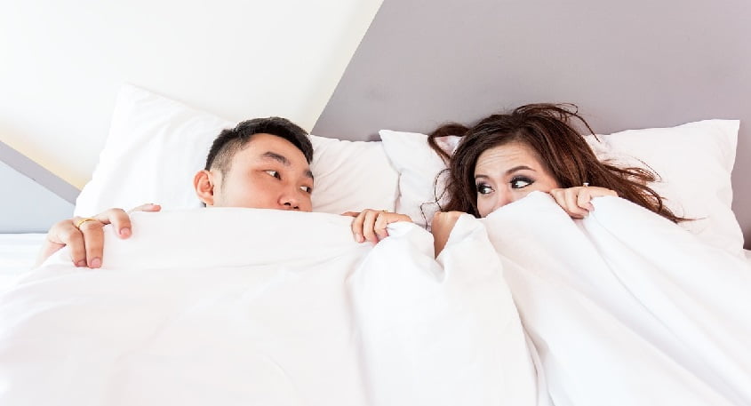 person with sexual partner on bed