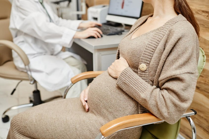 pregnant young woman consulting obgyn