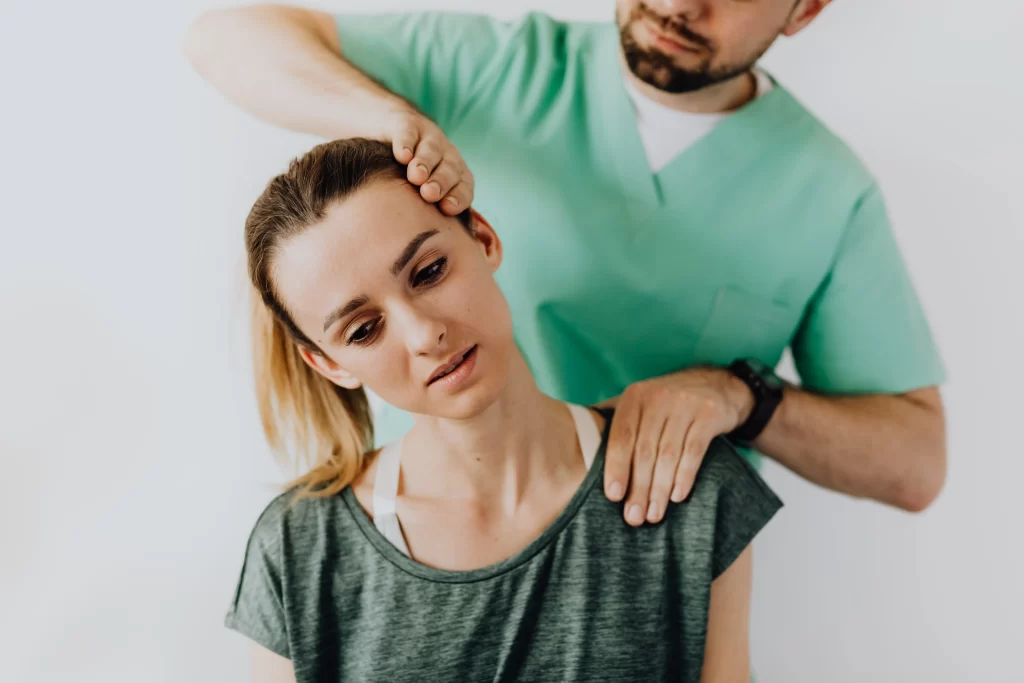 therapist treating a female patient's injured neck