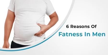 A man standing and holding his fatty stomach with his left hand, illustrating the causes of obesity in men
