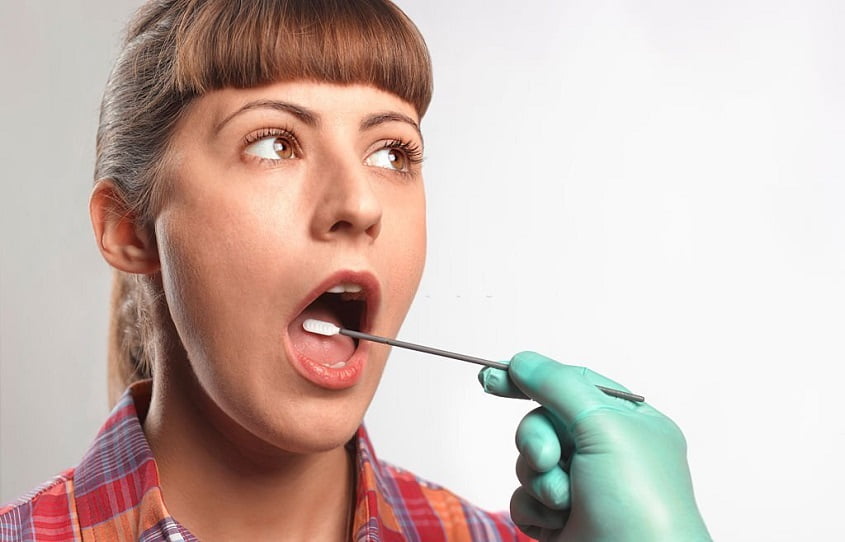 A Person putting DNA test swab into woman's mouth