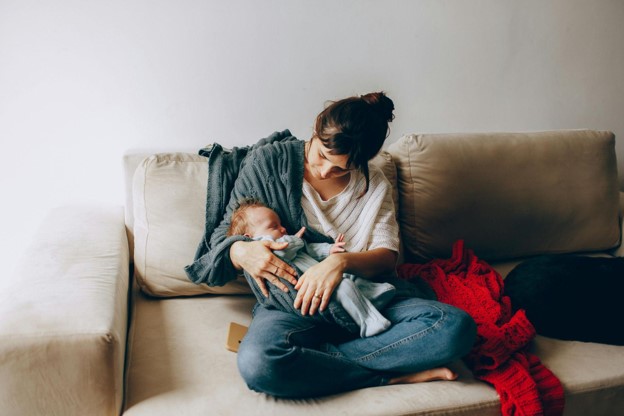 New mother breastfeeding her baby with support from a lactation consultant