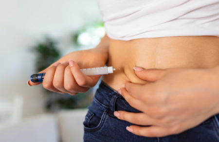 Person with type 2 diabetes using an insulin pen and continuous glucose monitor to manage blood sugar levels
