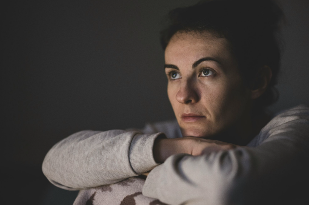 Exhausted parent sitting alone experiencing emotional burnout and mental fatigue