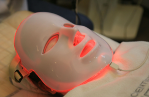 Emerging Wellness Technologies People Are Actually Using at Home Modern home wellness technology devices including red light therapy panel, wearable tracker, and PEMF therapy on patient