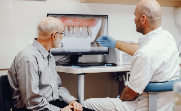 Dentist explaining dental implant treatment options to a patient with a missing tooth