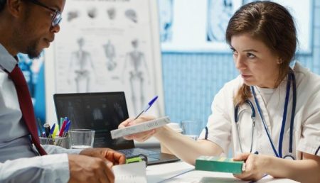 Patient consulting with a medical malpractice attorney while reviewing medical records and legal documents.