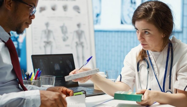 Patient consulting with a medical malpractice attorney while reviewing medical records and legal documents.