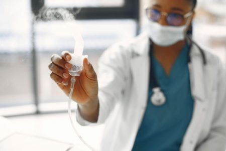How an Online Degree in Respiratory Care Supports Healthcare Leadership Respiratory therapist reviewing patient care and clinical performance data in lab.