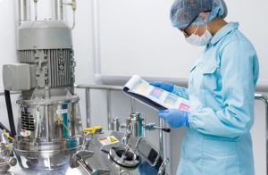 What Separates a Credible Supplement Manufacturer From the Rest Quality assurance specialist inspecting dietary supplement production and reviewing manufacturing certification documents.