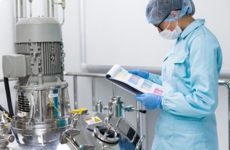What Separates a Credible Supplement Manufacturer From the Rest Quality assurance specialist inspecting dietary supplement production and reviewing manufacturing certification documents.