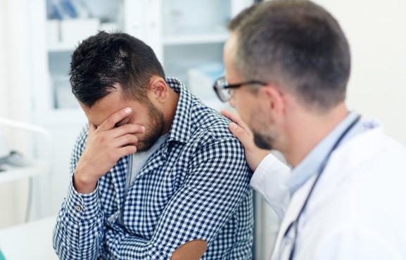 Healthcare provider discussing erectile dysfunction treatment options with an adult male patient during a private consultation.