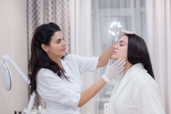 Facial plastic surgeon discussing facial rejuvenation treatment options with a patient.