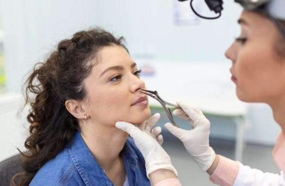 ENT or facial plastic surgeon examining a patient's nose before functional rhinoplasty.