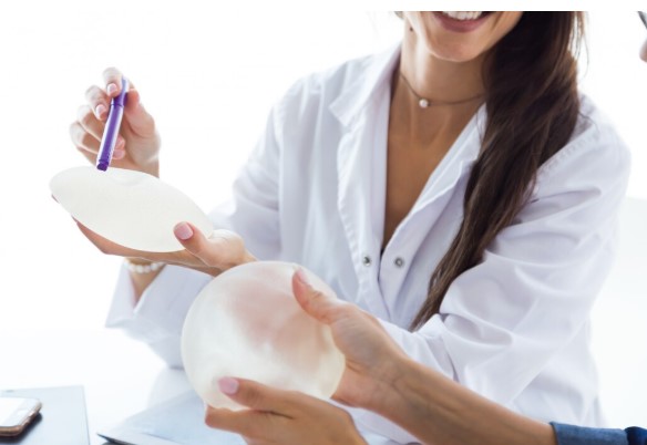 Plastic surgeon reviewing implants for a woman about personalized breast augmentation options.