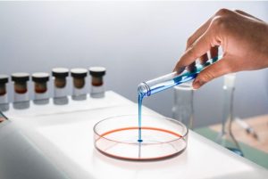 Muscle Recovery vs Cellular Metabolism: Comparing TB-500 and MOTS-c Research Researcher pouring blue liquid in glass dish