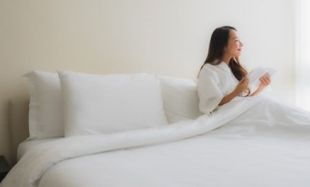 What Should a Firm Mattress Feel Like After 30 Nights? Person sitting comfortably on a firm mattress with proper spinal alignment in a modern bedroom.
