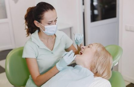 Dentist examining a patient's gums before planning denture treatment.