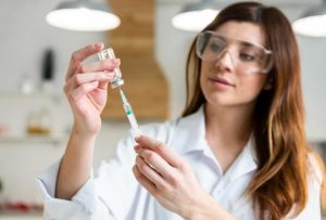 Female scientist holding syringe with peptides in the lab for weight loss treatment