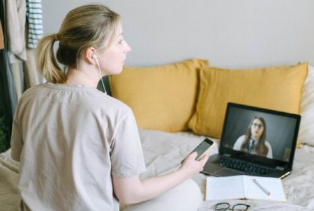 Weighing Virtual Addiction Treatment vs In-Person IOP Programs Person attending a virtual addiction treatment counseling session from home.