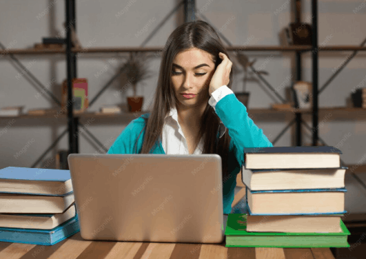 College student experiencing academic stress while studying with books and a laptop.