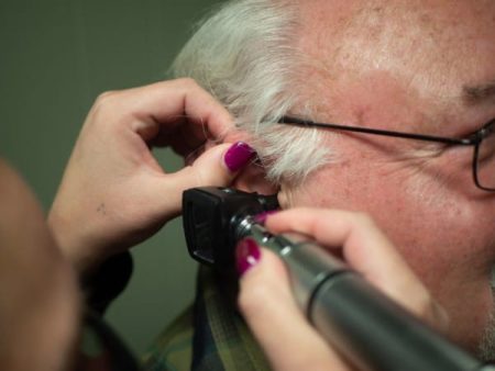 Audiologist testing an older adult's hearing